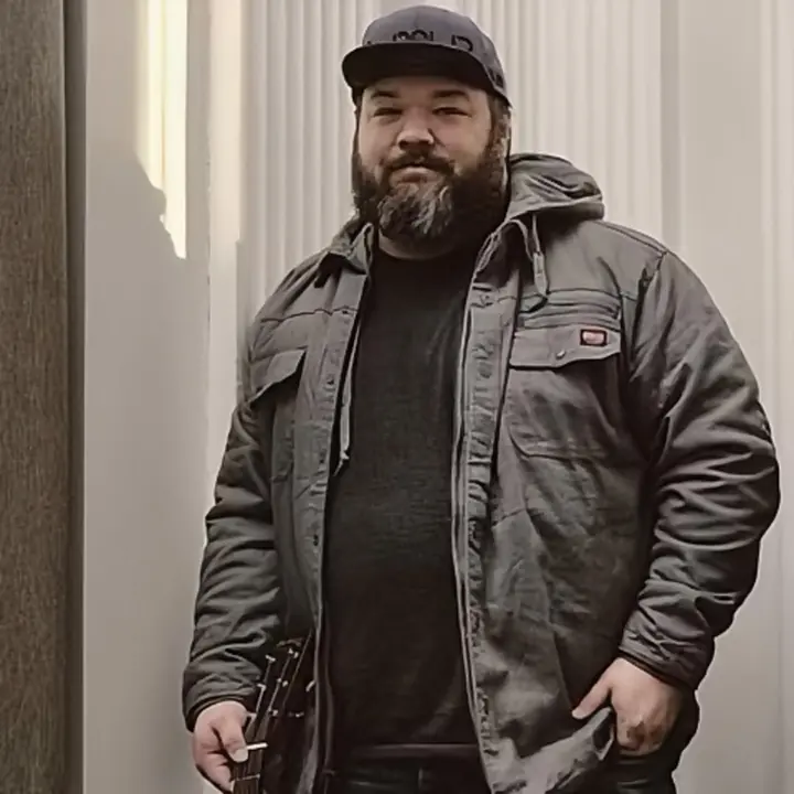 Marcus Clingaman standing with a guitar